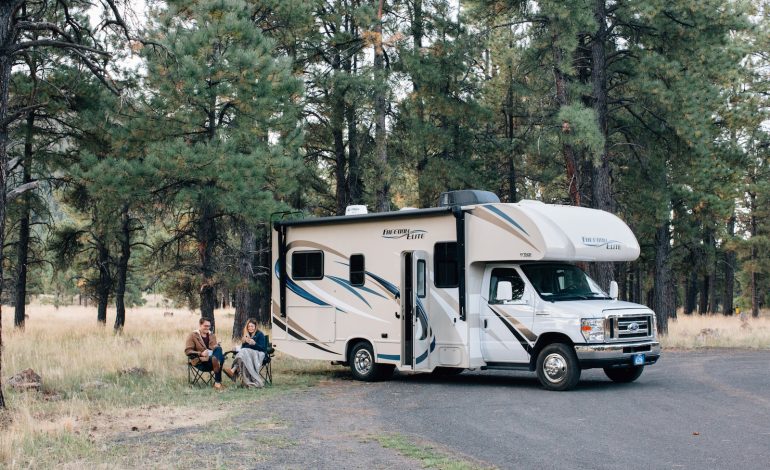 people standing near white rv trailer during daytime